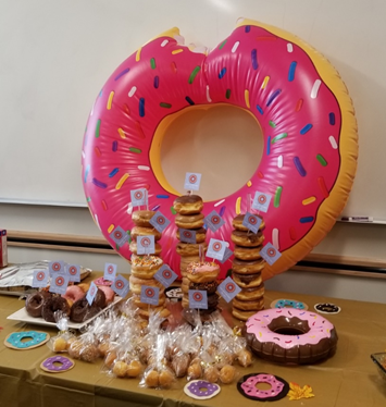 various party sweets on a table, with a donut balloon as decoration