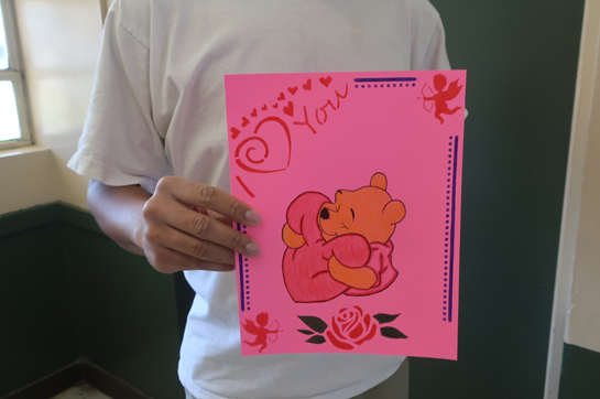 Youth displays his Valentine's Day creation featuring Winnie the Pooh. 