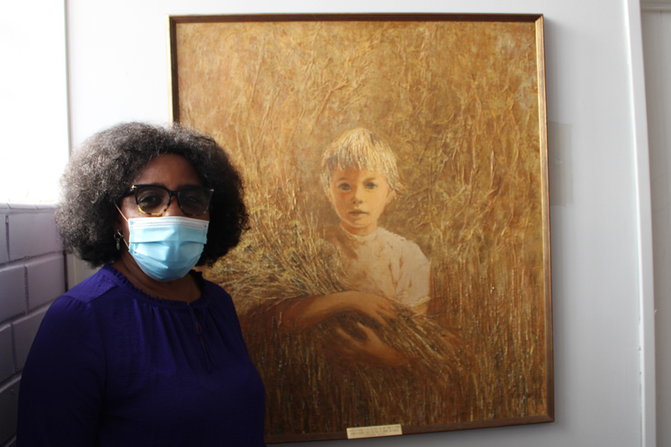 Youth Administrator Cynthia Brown with original art donated to decorate the newly refurbished lactation room at VYCF.