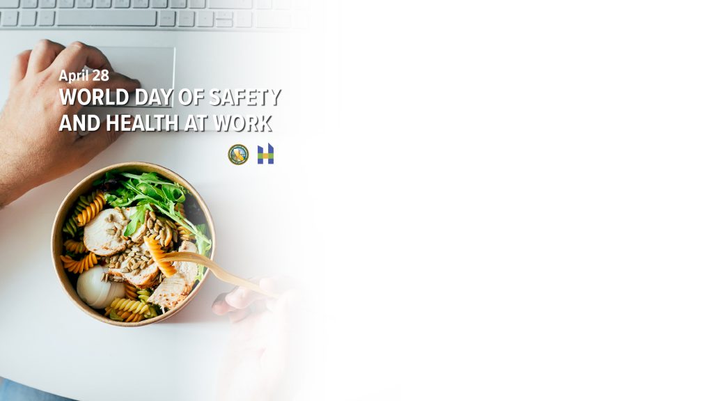 World day of Safety and health at work. Hand next to computer and healthy food.