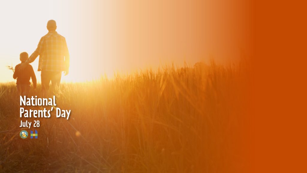 National Parents' Day parent and child walking in a field facing sunset