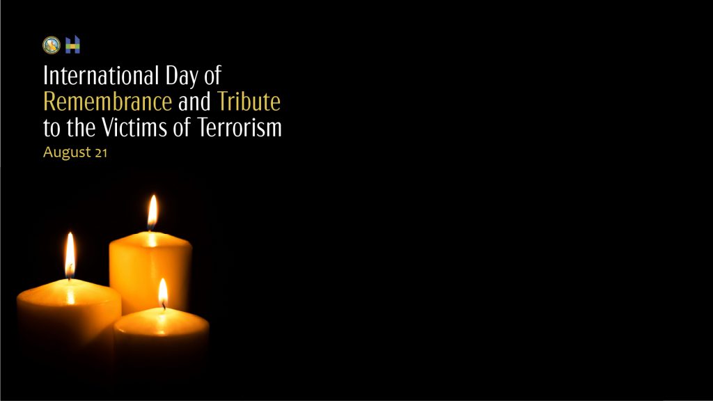 International Day of Remembrance and Tribute to the Victims of Terrorism August 21 on black background with lit candles.