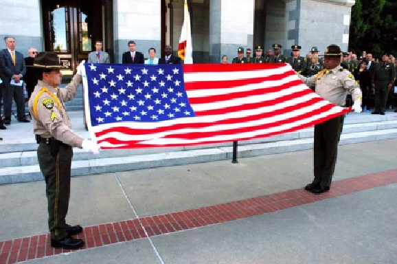 Correctional officers present flag at capitol.