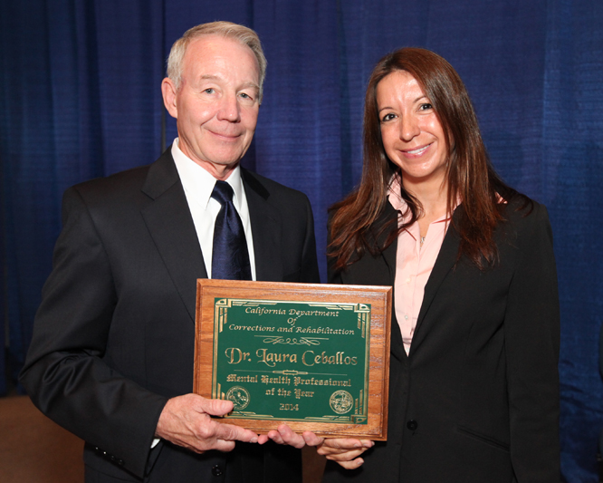 Two people with an award.