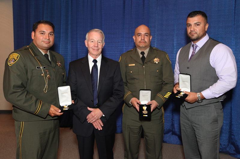 Three correctional staff with awards from Medal of Valor ceremony in 2014.
