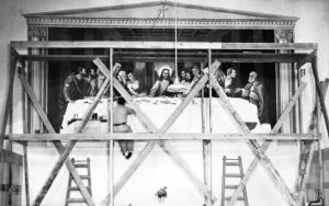 Artist Ralph Pecor sits on scaffolding while he paints at mural on a church wall at Folsom State Prison in 1938.