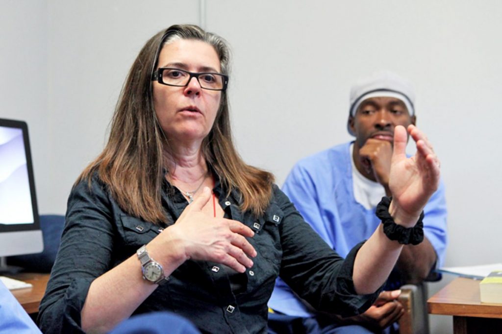 Woman speaks while an inmate listens.