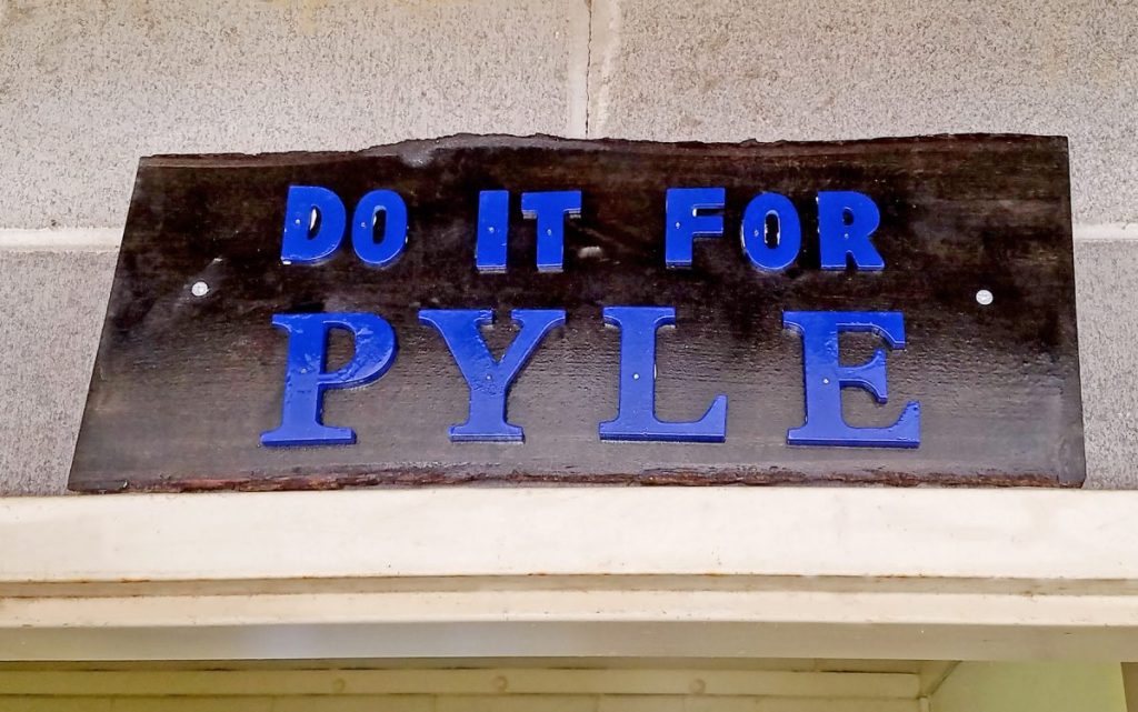 A sign says "Do it for Pyle."