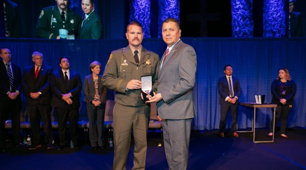 Officer Jason Peacock receives 2018 Medal of Valor from Secretary Ralph Diaz.