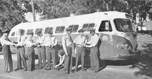 Training manual shows correctional officers stand in front of a bus.