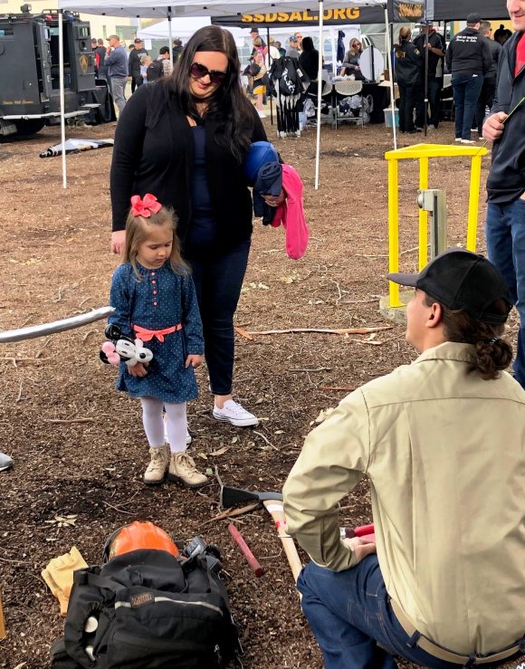 Kids Safety Fair at Guns and Hoses Pig Bowl with Pine Grove Youth Conservation Camp crew members.