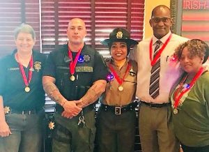 Men in women wear medals at a restaurant fundraiser.