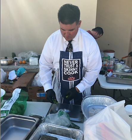 Man wears apron that says Never Trust a Skinny Cook. 