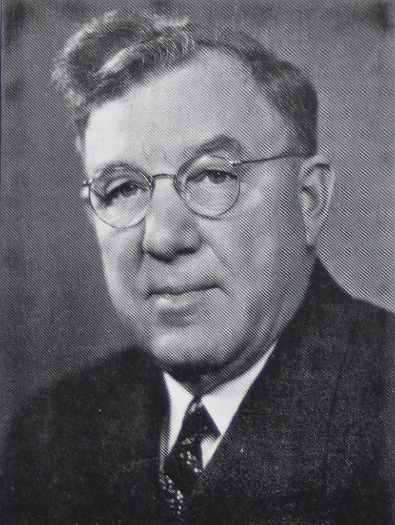 Man in glasses, jacket and tie.