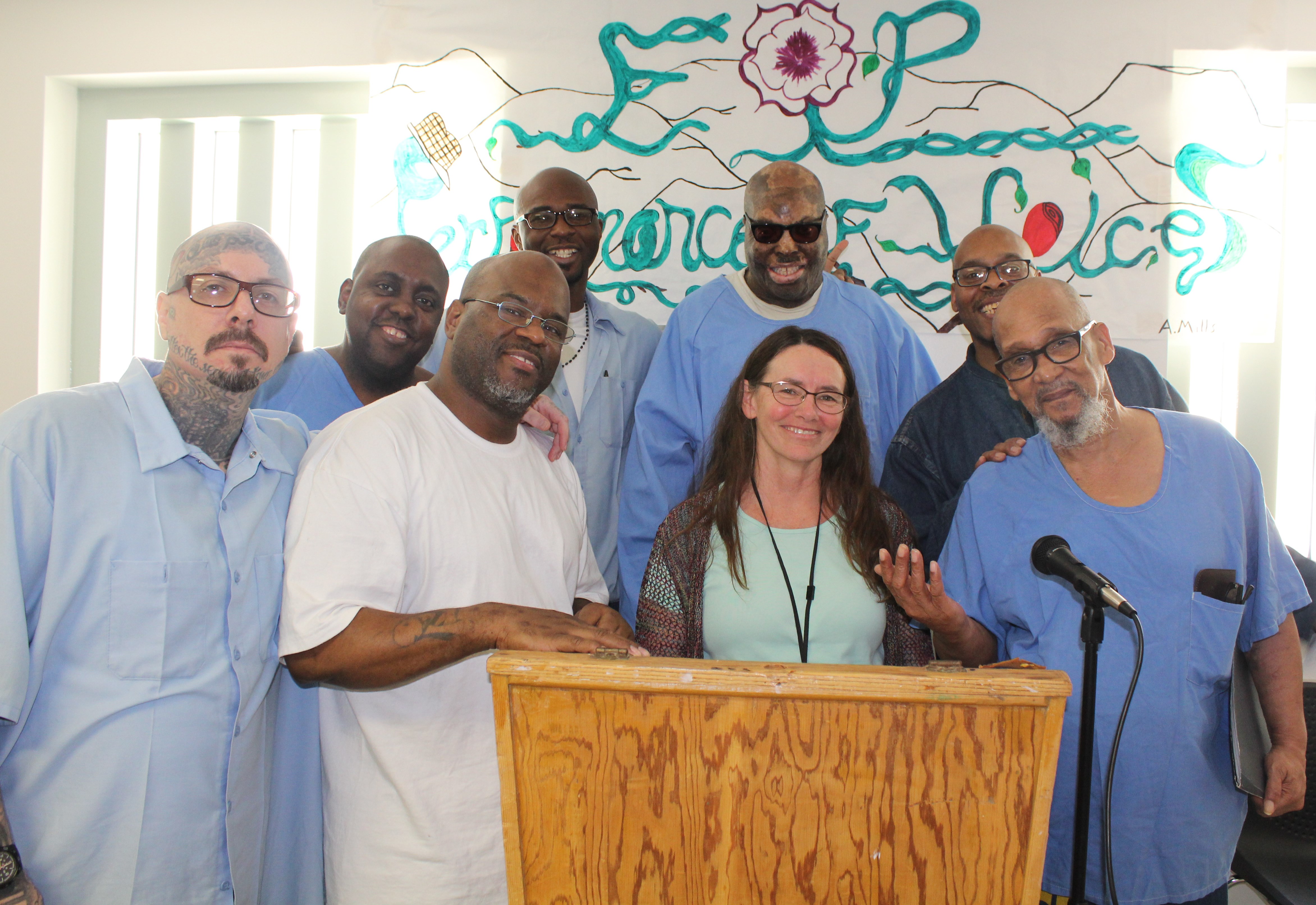 CMF incarcerated residents read poetry from a lectern to the mental health staff.