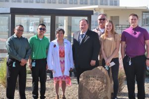 Men and women stand behind a memorial to Al Patch.