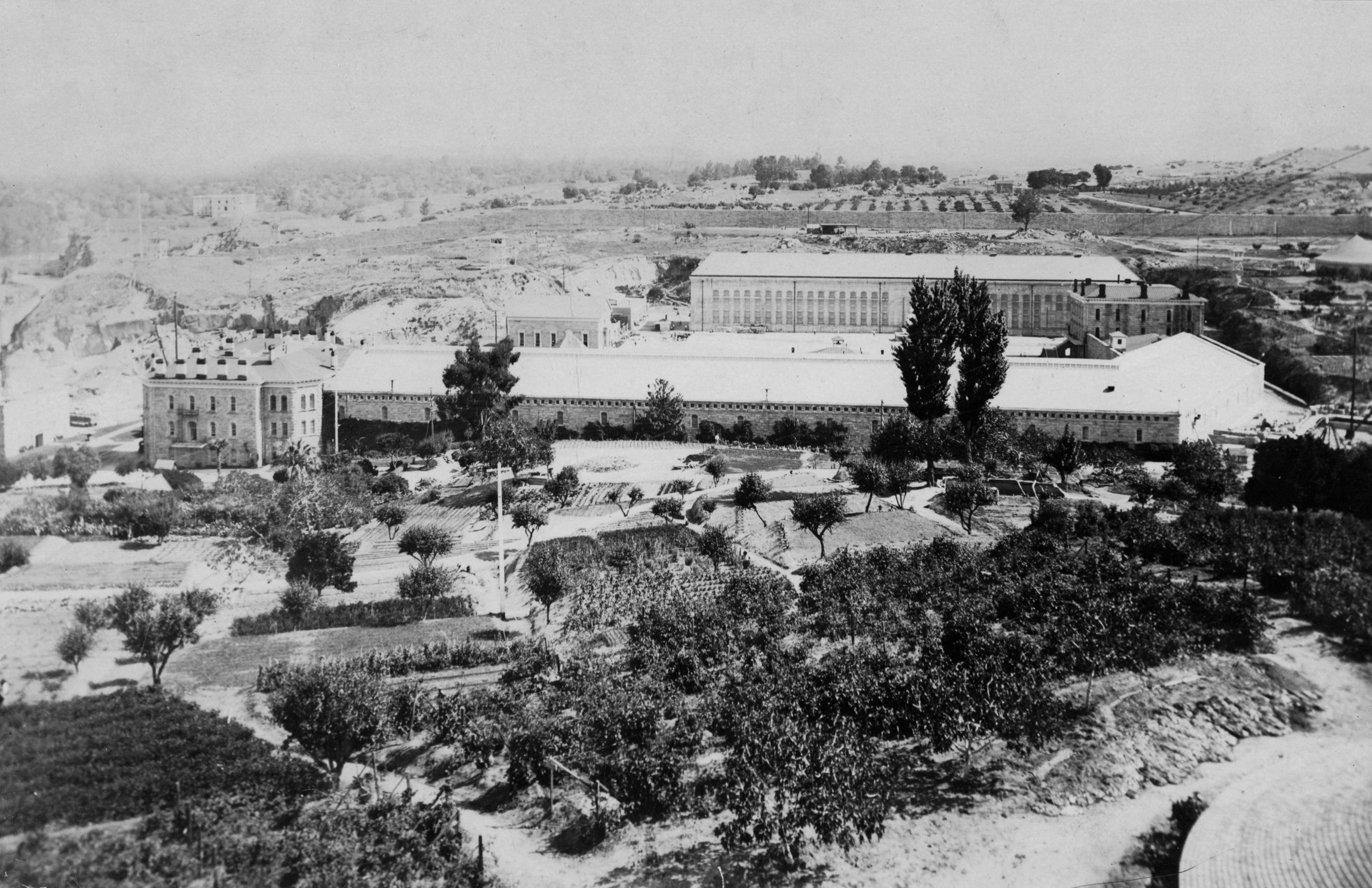 A farm in the foreground and prison in the background.