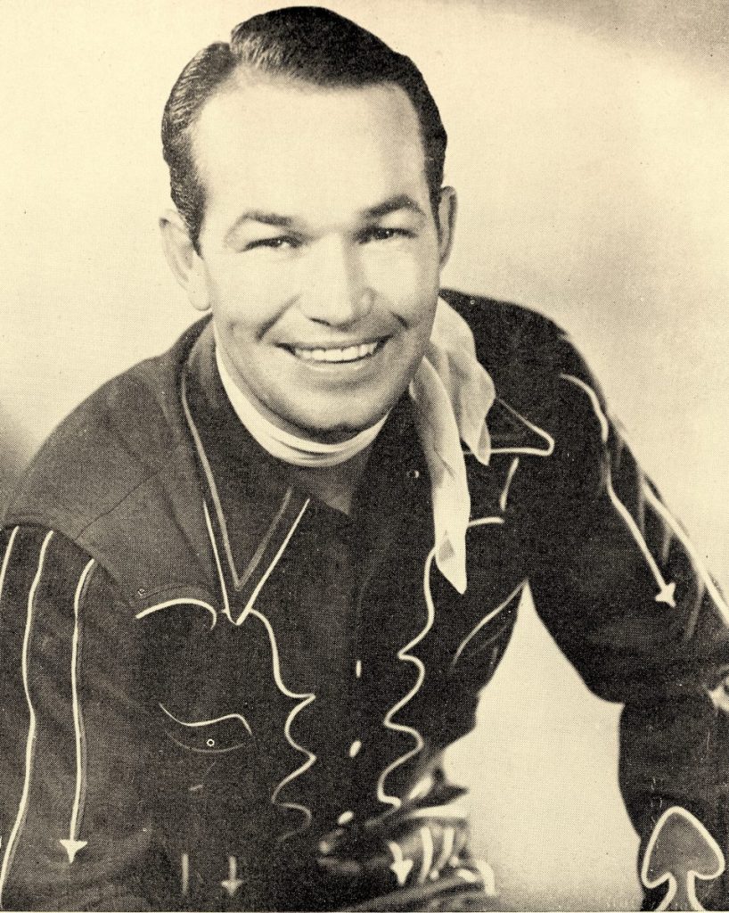 Smiling man in 1950s style cowboy outfit. 