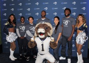 Football team mascot and two cheerleaders flank five youth.