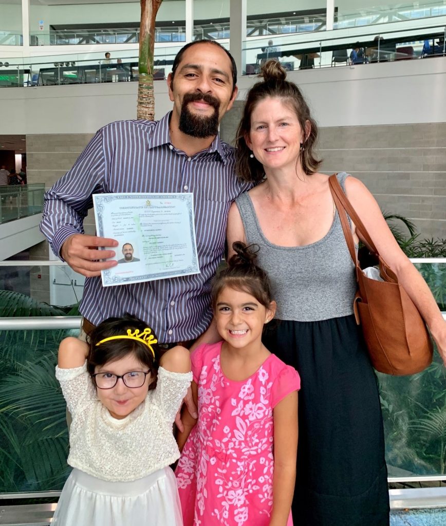 Werner Ruiz holding citizenship paper with wife and two small daughters