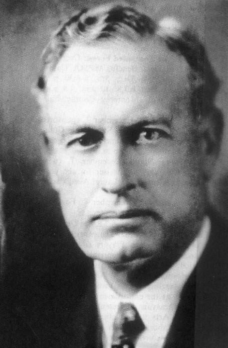 Photo of man wearing tie and staring into the camera.