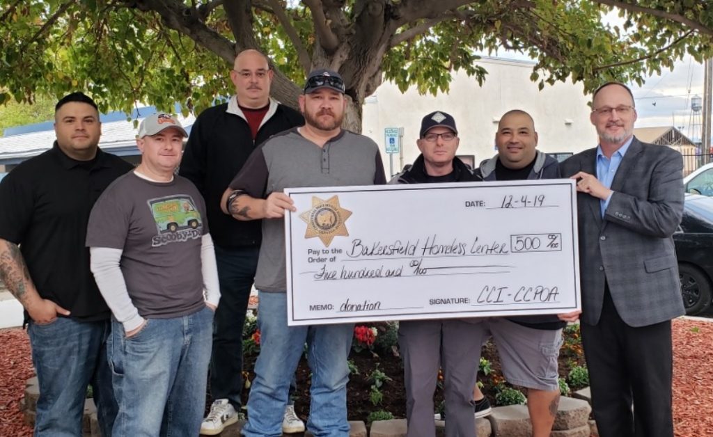Correctional staff present an oversized check.