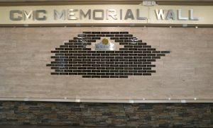 A wall with small name plaques and the words "CMC Memorial Wall" across the top.