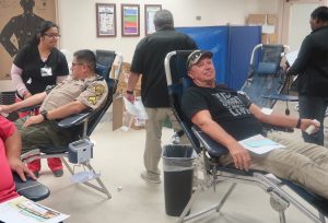 Two men lie down to donate blood.
