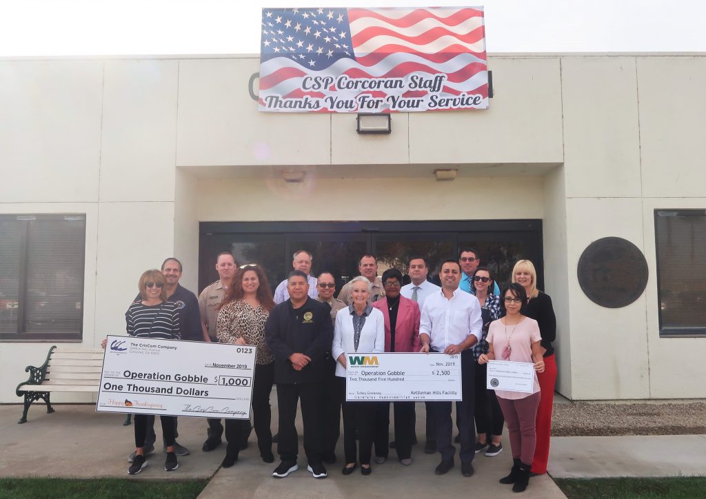 Corcoran prison staff present oversized checks to charities.