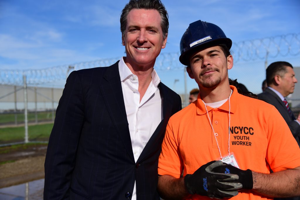 California Governor Gavin News poses with a youth offender who is enrolled in a job-training program.