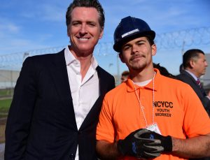 California Governor Gavin News poses with a youth offender who is enrolled in a job-training program.