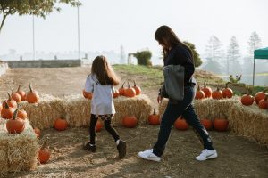 Kids and an incarcerated parent walk among pumpkins at Folsom Women's Facility.