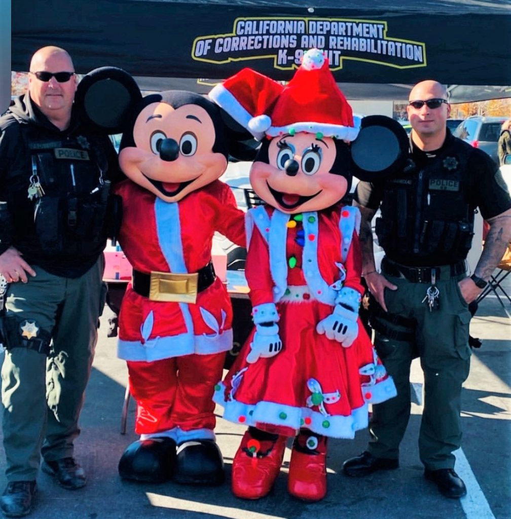 Two officers flank Mickey and Minnie Mouse.