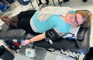 woman on bed donates blood.