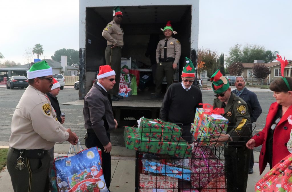 Correctional staff unload a large truck full of wrapped presents.