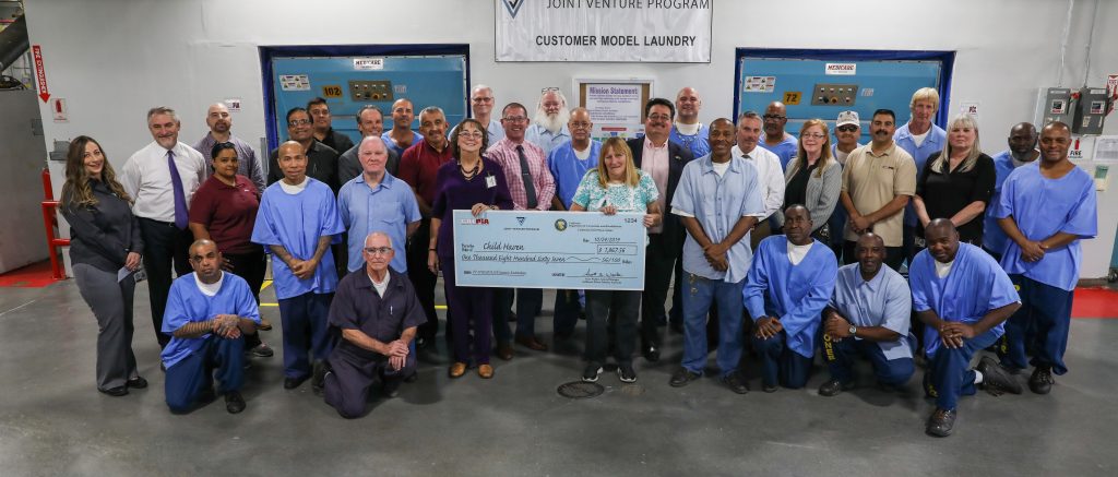 People standing behind and next to one big check