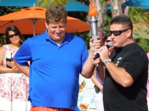 Two men hold a torch.