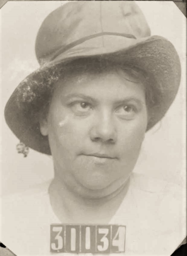 Woman wearing hat in San Quentin mugshot.