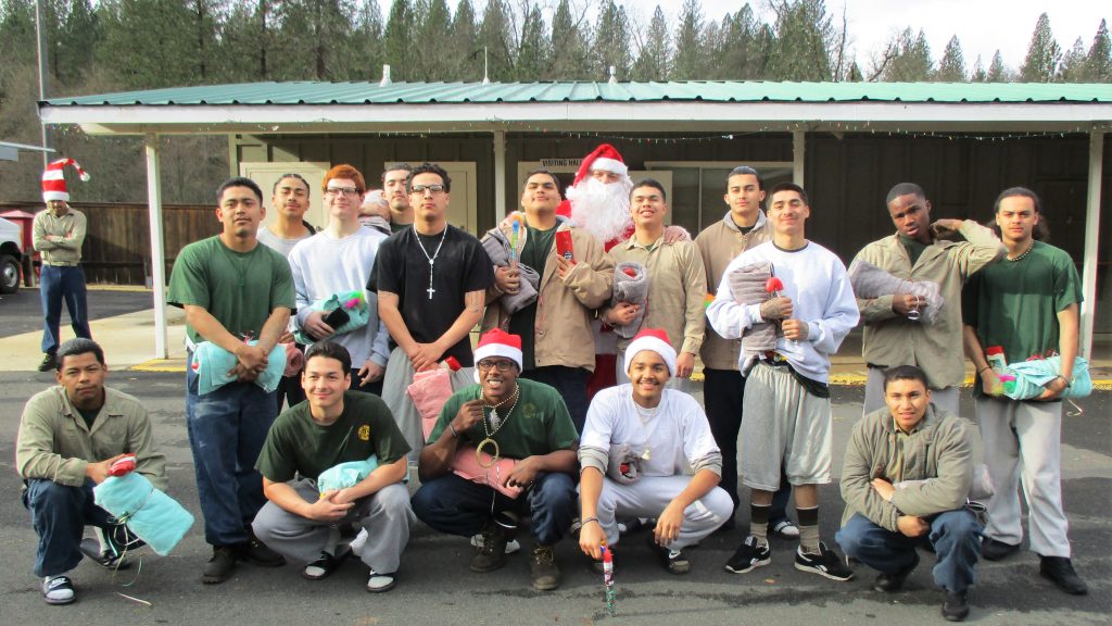 Youth fire camp offenders pose with a man in a Santa Claus costume.