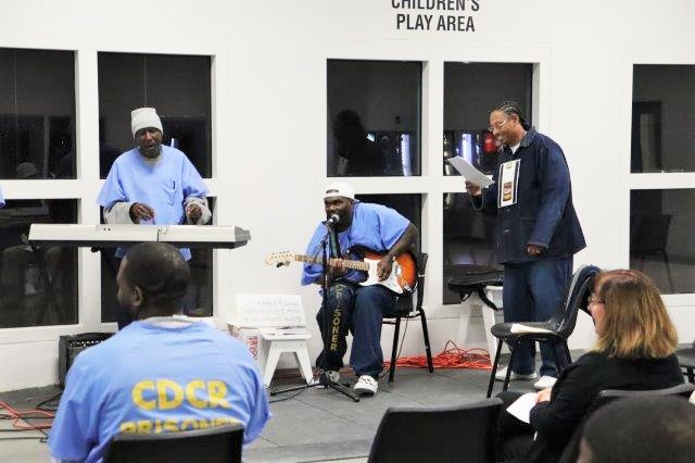 Prison inmates perform on instruments.