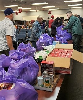 Men set up a table with boxed and canned food for the needy.