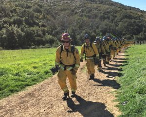 Firefighters hike on a trail in Ventura County.