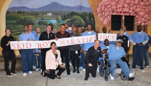 CDCR Secretary Ralph Diaz and Superior Court Judge Craig Mitchell with inmates holding a banner that reads "Skid Row Marathon, RJDCF."