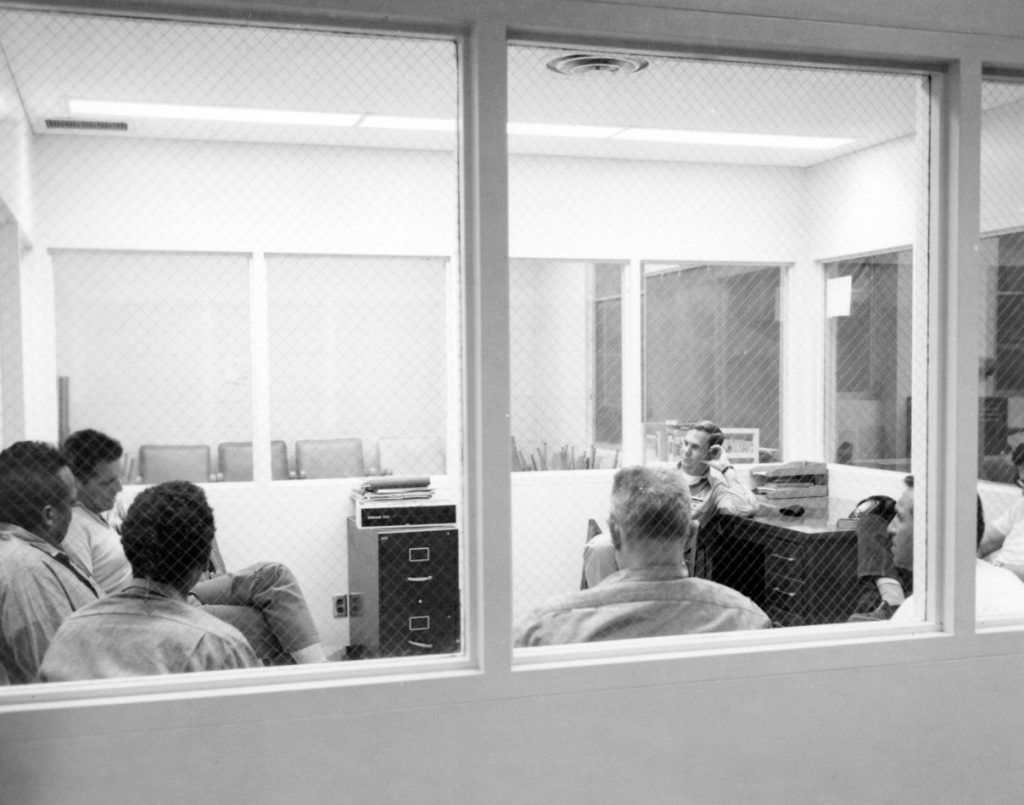 Seven men sit in a room for group counseling at California Institution for Men.