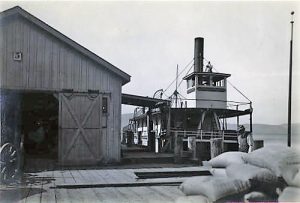 A steam ship at a wharf, another man walking in front, at San Quentin prison.