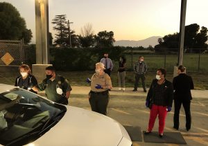 Men and woman wait at a prison entrance.