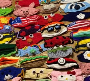 Photo of crocheted masks of different colors, characters and sizes.
