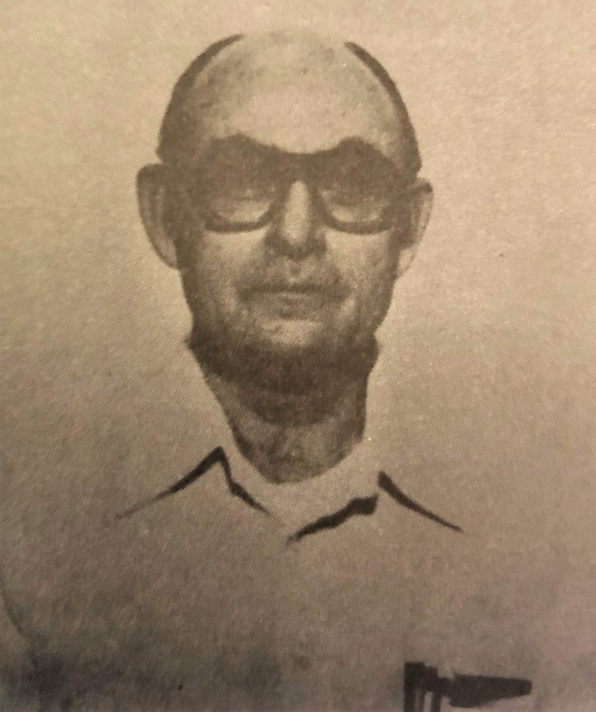 Grainy photo of man wearing glasses.