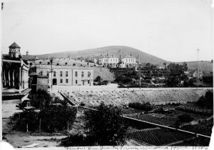 Late 1800s image of San Quentin prison, now known as San Quentin Rehabilitation Center, some buildings, a garden and a large house.
