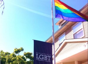 LGBT sign and rainbow flag in front of a building.
